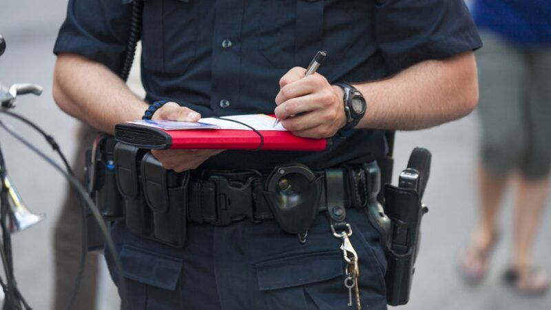 Police officer writing a ticket | Peterfactors / Dreamstime.com