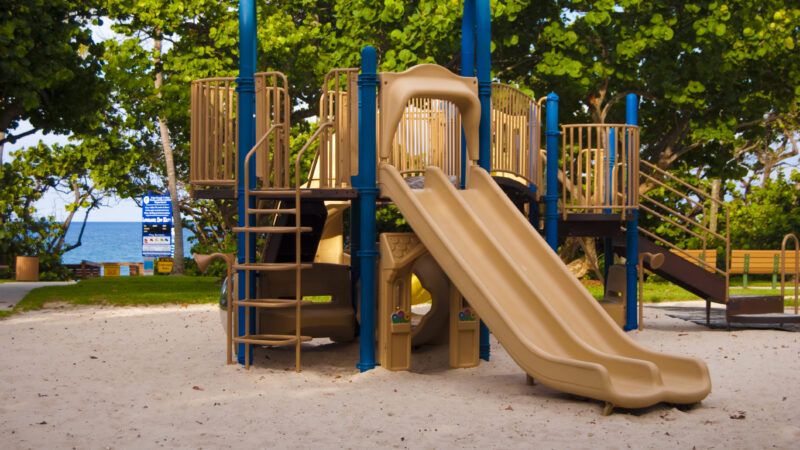 Tan and blue play equipment at a park |  EmeraldUmbrellaStudio | Dreamstime.com