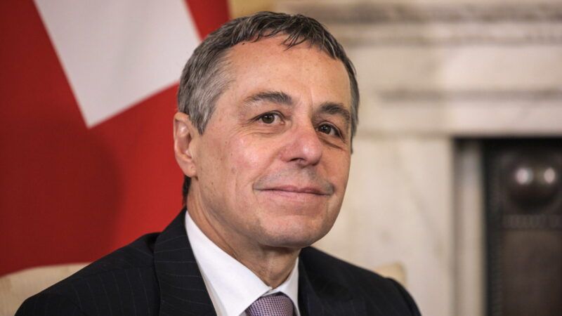 Swiss President Ignazio Cassis seated in front of the Swiss flag | Rob Pinney/ZUMA Press/Newscom