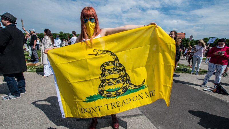 Woman holding "Don't Tread on Me" flag