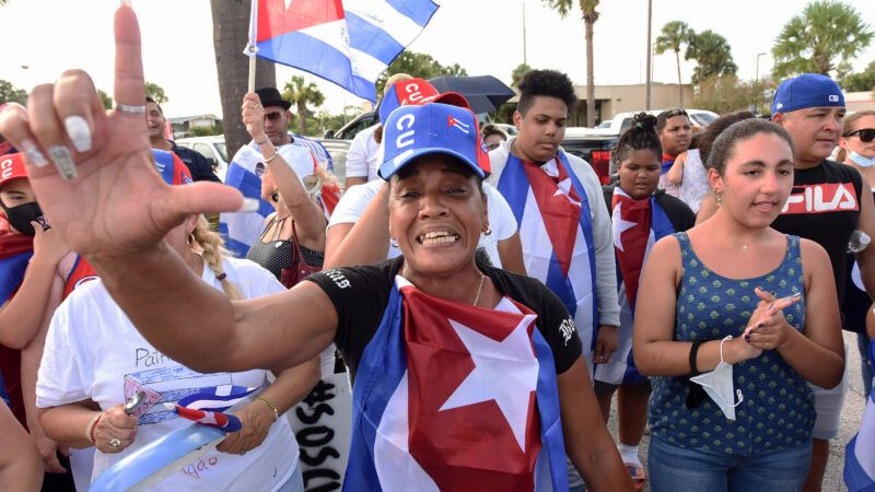 A Cuban-American woman at a protest makes a pro-democracy gesture at a protest