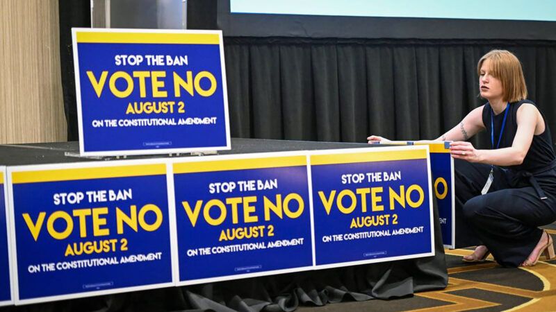 Woman putting up 'Vote No' signs in Kansas to "stop the ban" on abortion | Tammy Ljungblad/TNS/Newscom