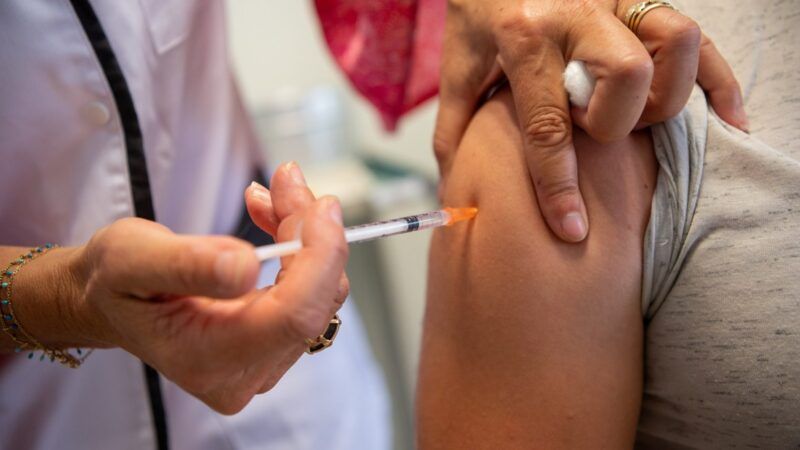 someone receiving a vaccine injection in their arm