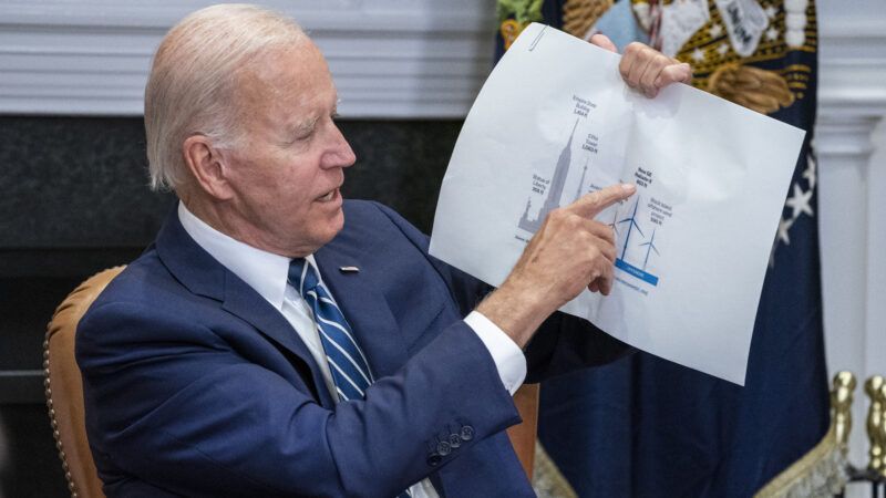 Biden points to a wind turbine graph on a piece of paper