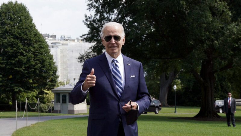 A photo of Joe Biden wearing sunglasses and giving a thumbs up in front of the White House | Pool/ABACA/Newscom
