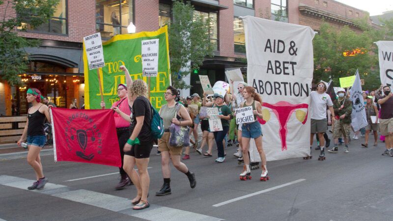 pro-choice protesters with sign that says "aid and abet abortion"