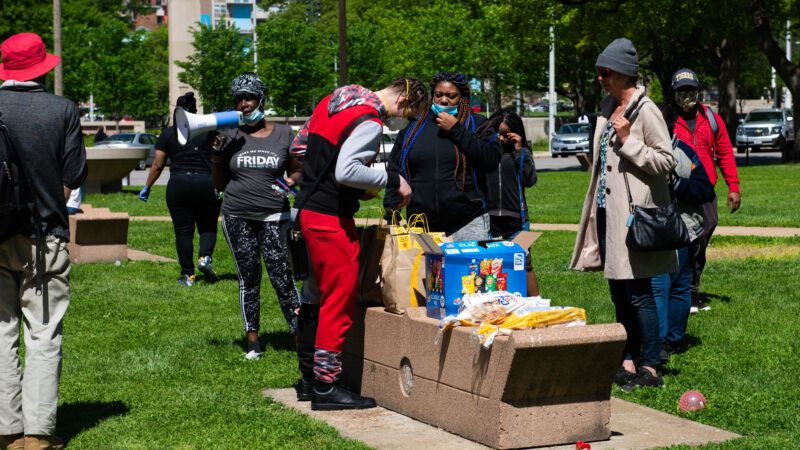 Man distributing masks and food to homeless camp residents | James Cooper/ZUMA Press/Newscom