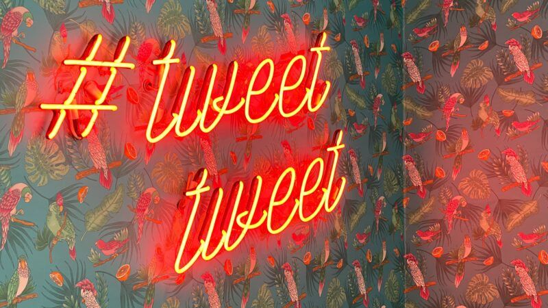 neon sign with a hashtag saying "tweet tweet"