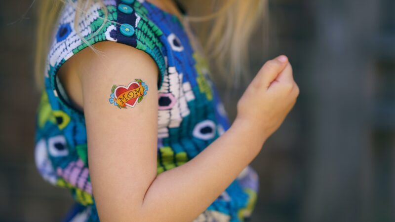 girl with temporary tattoo that says mom