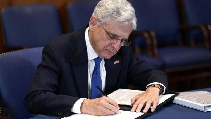 Attorney General Merrick Garland signs a document.