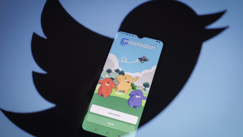 Mastodon app on phone with Twitter logo in background