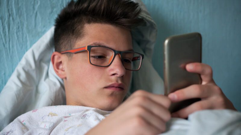 Teenager staring at his phone.