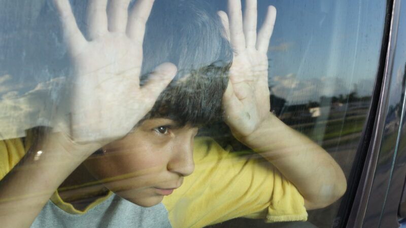 Boy behind a car window