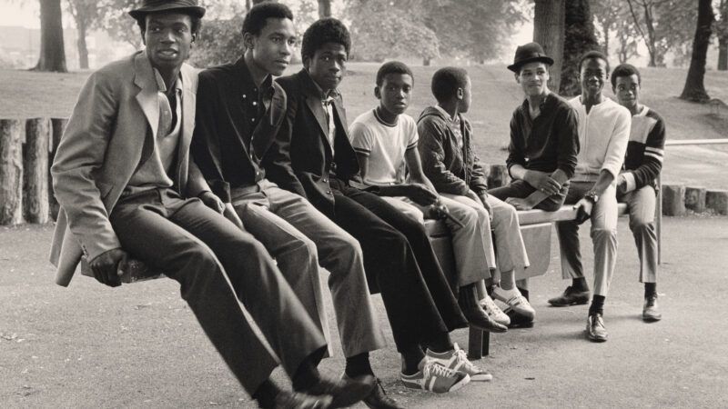 African American men sitting on benches in a photograph in Great Britain