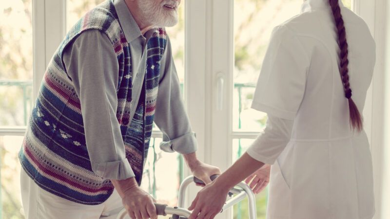 A female nurse helps a senior man in a nursing home | Photo 146014635 © Katarzyna Bialasiewicz | Dreamstime.com