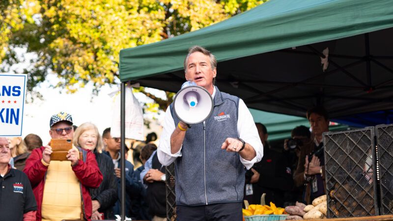 Virginia Gov. Glenn Youngkin stands in front of a green awning speaks into a loudspeaker. | Photo 233399291 © Eli Wilson | Dreamstime.com