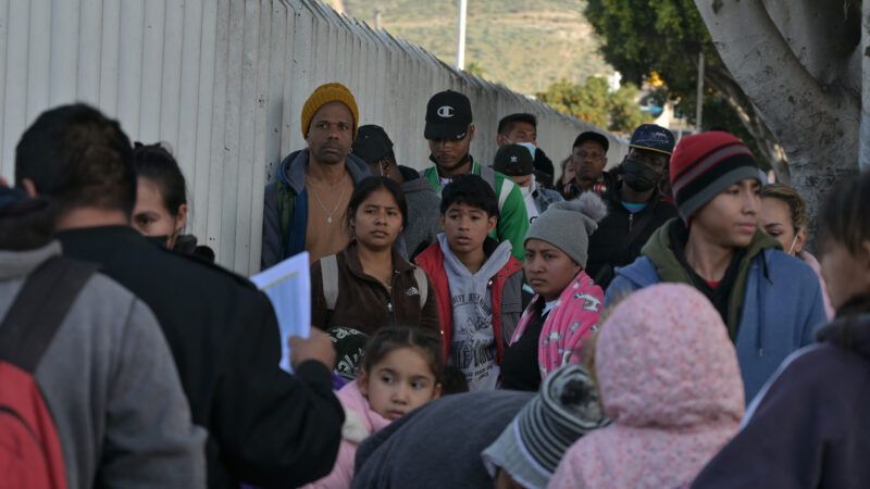 Migrants wait in line at the U.S.-Mexico border
