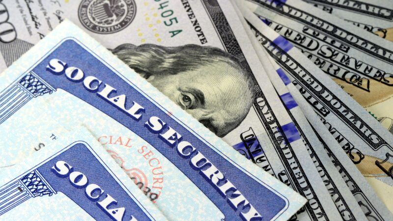 Two Social Security cards are seen on top of a stack of money | Photo 35464574 © Larryhw | Dreamstime.com