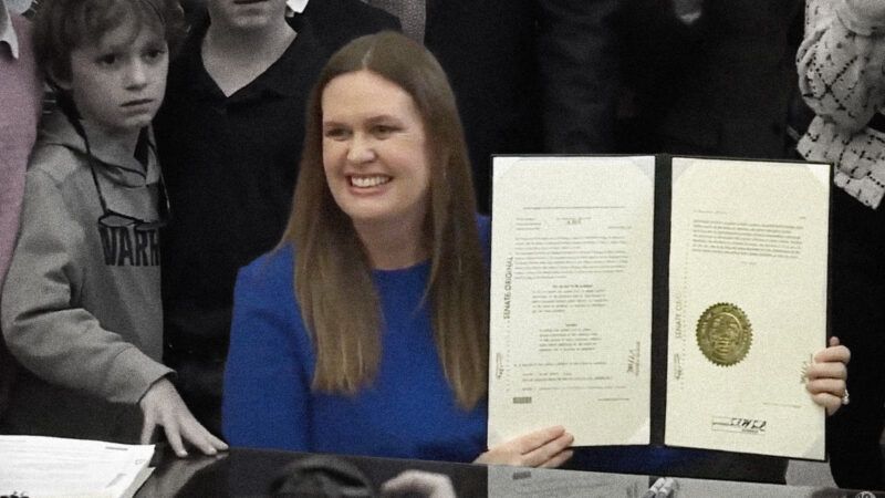 Arkansas Gov. Sarah Huckabee Sanders holds up a copy of the Youth Hiring Act after signing it into law.