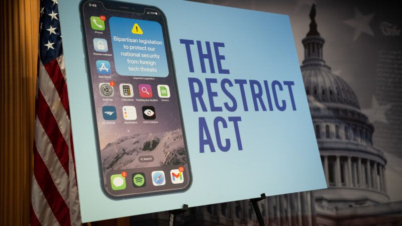 A display poster set up on an easel, featuring a mockup of an iPhone home screen next to the words "THE RESTRICT ACT."