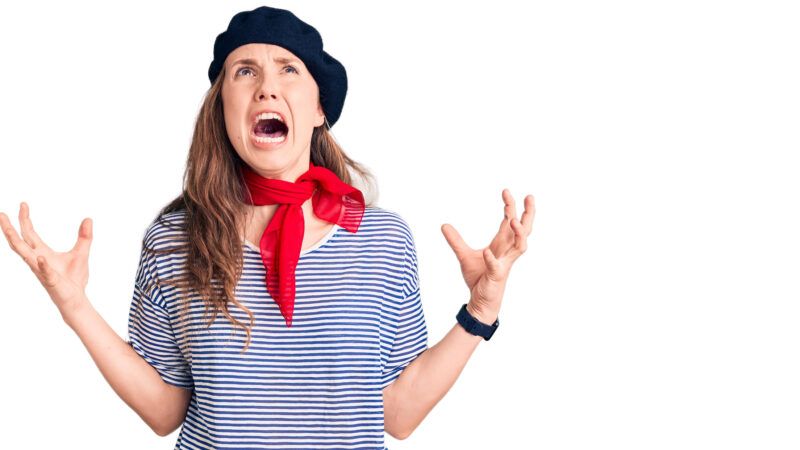 A blonde woman in a beret and a black-and-white striped shirt with a red kerchief, screaming.