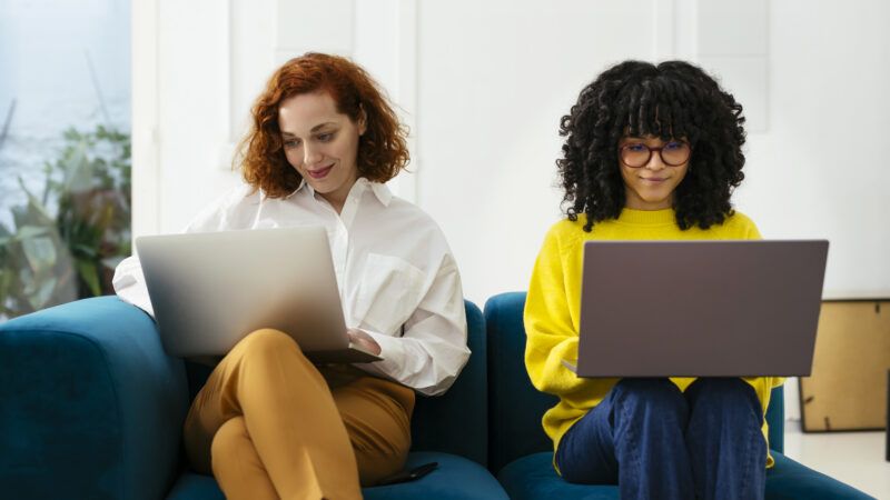 two happy women on laptops | Bonninstudio/Westend61 GmbH/Newscom