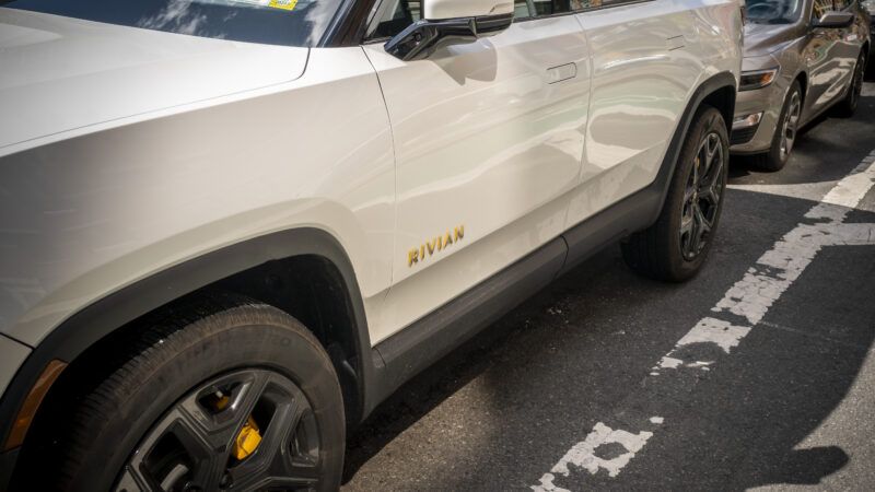 A white Rivian R1S all-electric SUV sits parked on the street in New York City.