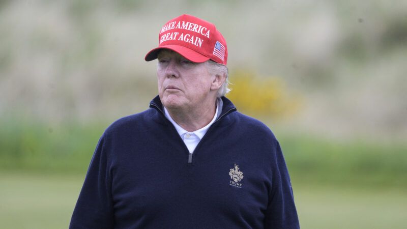 Trump in MAGA hat looking off into the distance