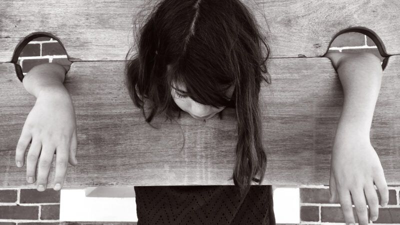 child in old-fashioned pillory