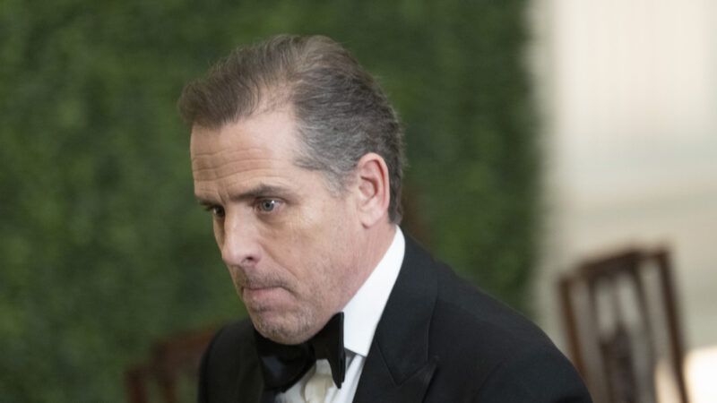 Hunter Biden wearing a tuxedo in front of a green background.