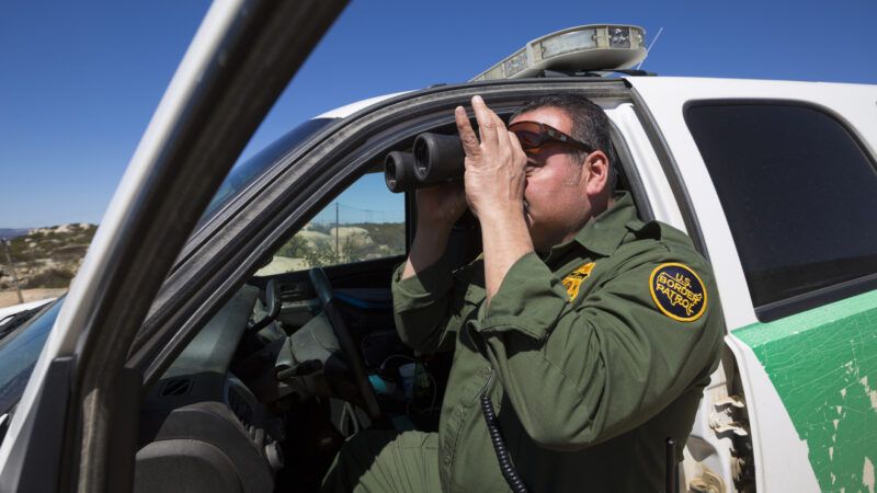 A U.S. Border Patrol agent looks through binoculars while patrolling. | Maxironwas | Dreamstime.com