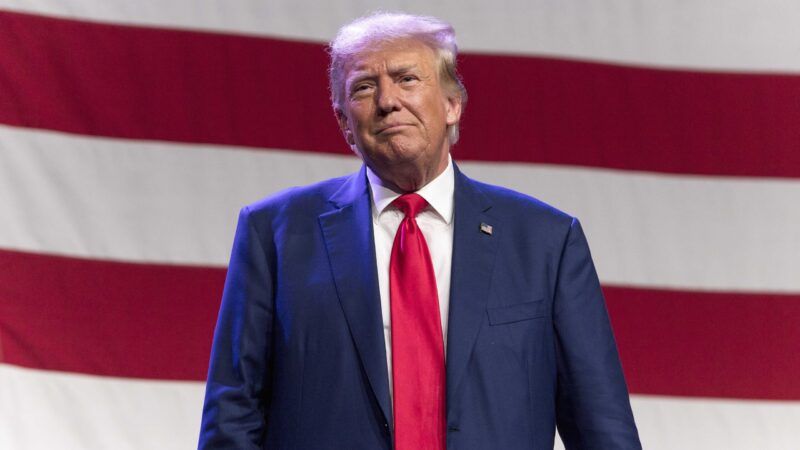 Donald Trump in front of a large American flag | Brian Cahn/Zuma Press/Newscom