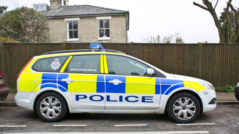 A U.K. police patrol car sits roadside on a residential street. | Thomas Gowanlock | Dreamstime.com