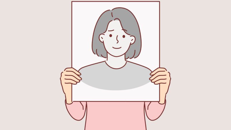 person holding a picture of a face in front of their real face | ALPHAVECTOR/Newscom