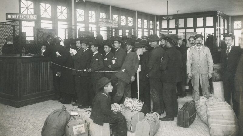Immigrants at Ellis Island, 1910 | Photo by <a href="https://unsplash.com/@nypl?utm_content=creditCopyText&utm_medium=referral&utm_source=unsplash">The New York Public Library</a> on <a href="https://unsplash.com/photos/grayscale-photo-of-a-group-of-immigrants-with-bags-inside-MiVrRlSe4BI?utm_content=creditCopyText&utm_medium=referral&utm_source=unsplash">Unsplash</a>   