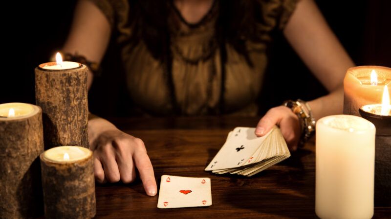 A female psychic telling someone's fortune using playing cards. | Miriam Doerr | Dreamstime.com