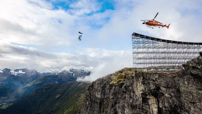 Tom Cruise flying through the air after going off a motorcycle jump during filming for a Mission Impossible movie | Photo: Tom Cruise on the set of Mission: Impossible—Dead Reckoning Part One, 2023; Christian Black/© Paramount Pictures/Courtesy Everett Collection