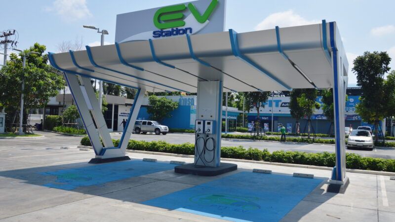 A public electric vehicle charging station labeled "E.V. Station" | Akaphat Porntepkasemsan | Dreamstime.com