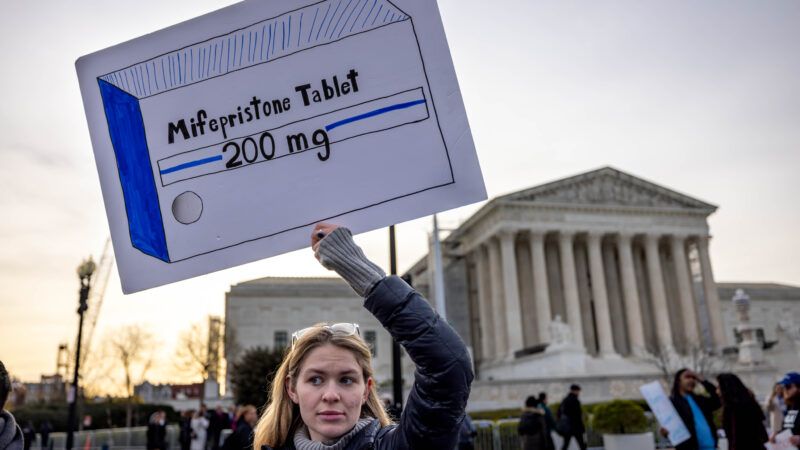 pro-choice protestor holding up a sign depicting an abortion drug | Michael Nigro/ZUMAPRESS/Newscom