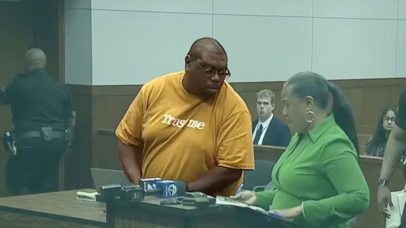 Corey Harris is seen in a shirt that says "Trust me" during a hearing in a Washtenaw County court | YouTube