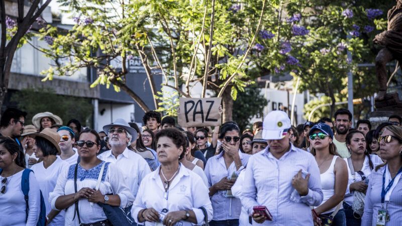 Crowd of protesters in Guadalajara, Mexico, calling for an end to drug cartel violence. One holds a handwritten sign that says "PAZ" ("peace"). | Toni Rodriguez/dpa/picture-alliance/Newscom