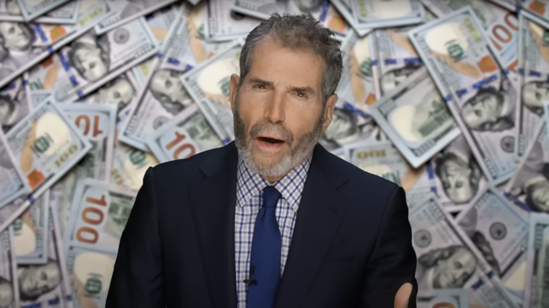 John Stossel is seen in front of stacks of $100 bills | Stossel TV