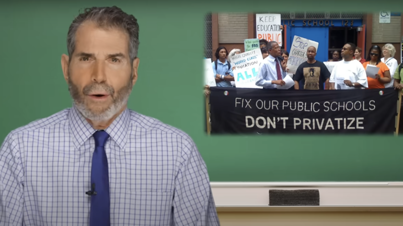 John Stossel is seen next to a sign that says, "Fix our public schools, Don't privatize" | Stossel TV