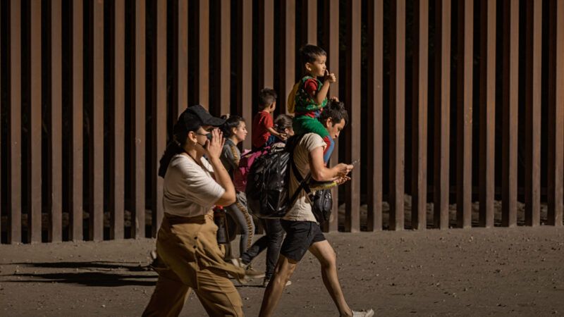 A group of immigrants walk along the U.S.-Mexico border wall in Yuma, Arizona | Qian Weizhong/VCG/Newscom
