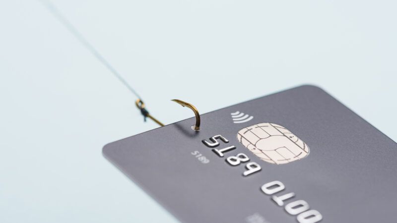 A credit card with a fishhook through it and fishing line, signifying a phishing attempt. | Nevodka | Dreamstime.com