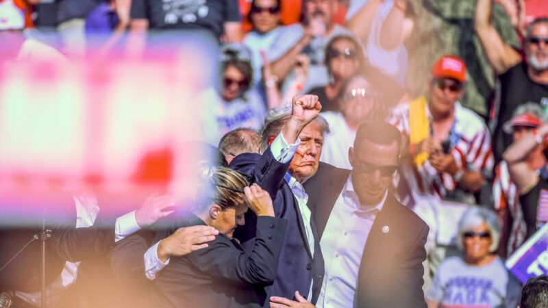 Former President Donald Trump holds up a fist as Secret Service agents escort him offstage, after an assassin tried to shoot him during a rally in Butler, Pennsylvania. | Morgan Phillips/Polaris/Newscom