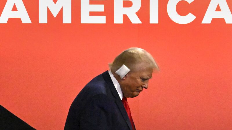 Donald Trump with a bandage on his ear in front of a sign reading 'America' at the Republican National Convention | MATT MARTIN/UPI/Newscom