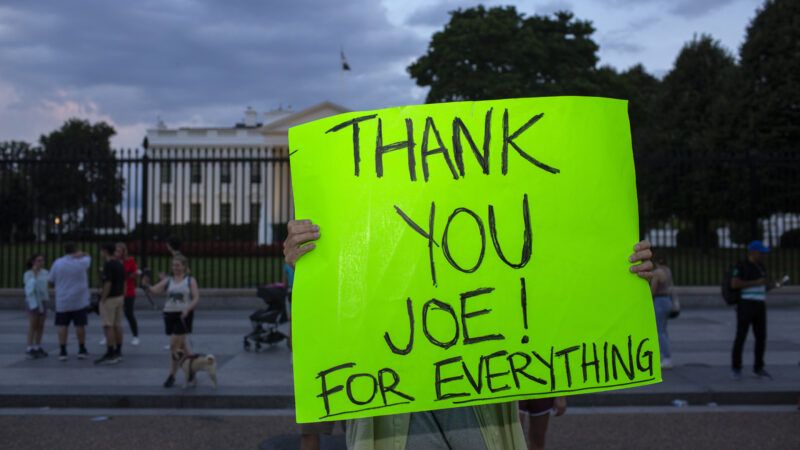 A demonstrator outside the White House holds a neon green poster board sign that says "THANK YOU JOE! FOR EVERYTHING" | Probal Rashid/ZUMAPRESS/Newscom