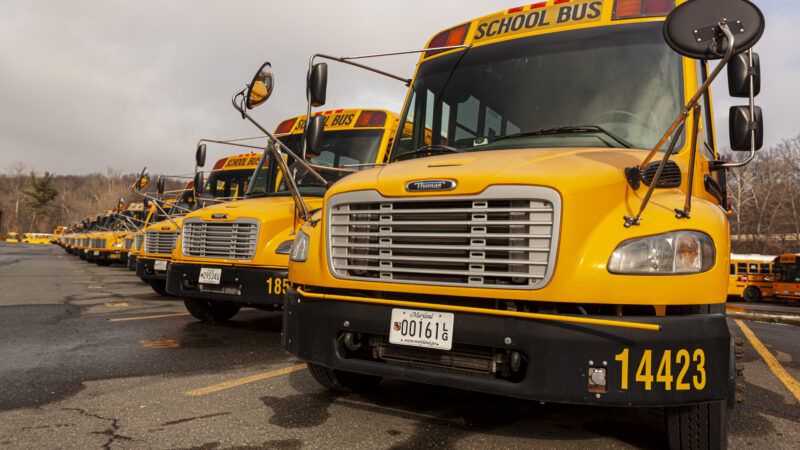 A row of yellow school buses in a parking lot in Bethesda, Maryland | Grandbrothers | Dreamstime.com