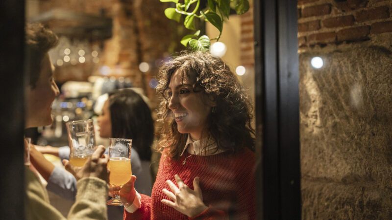 A woman in a bar holding a drink | Jose Carlos Ichiro/Westend61 GmbH/Newscom